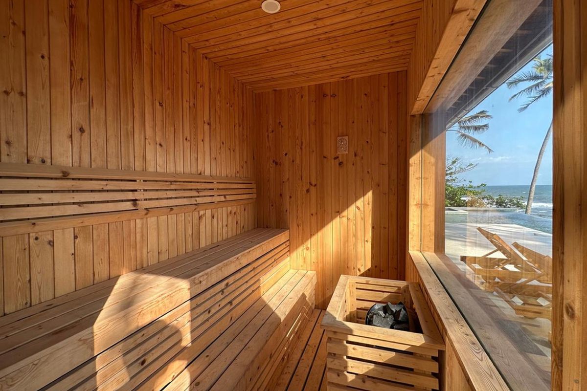 Traditional sauna with a stone heater and wooden benches overlooking the ocean